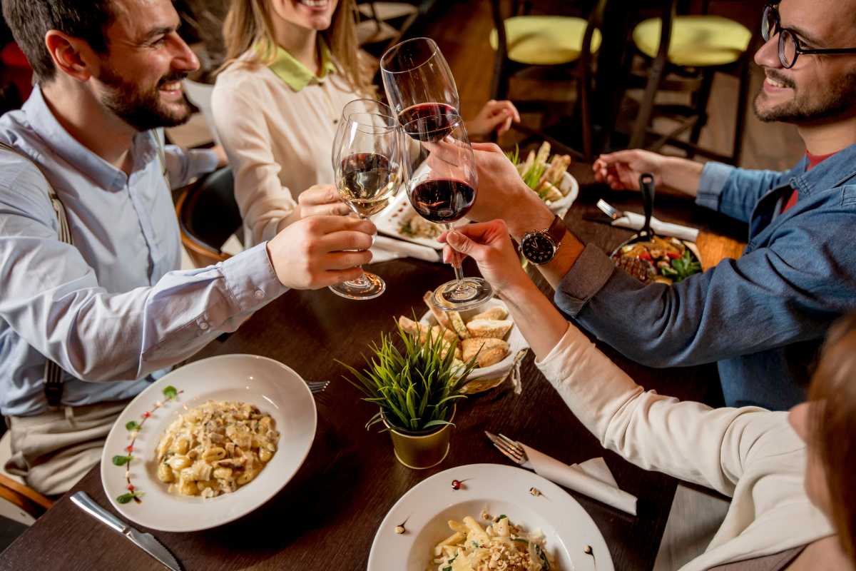 Tavolata rustica in centro storico di Ostuni, piatti tipici pugliesi, pane, olio, vino locale, atmosfera conviviale